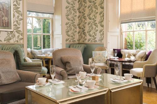 a dining room with chairs and tables and windows at Lainston House in Winchester