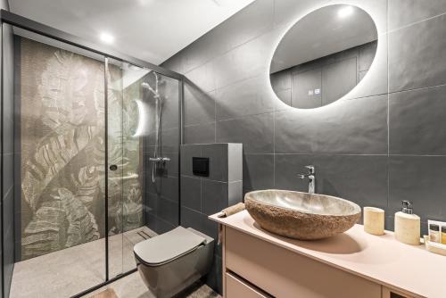a bathroom with a sink and a toilet and a mirror at Dunique Summer in Palanga