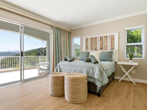 a bedroom with a bed and a balcony at Coney Glen Penthouse in Knysna