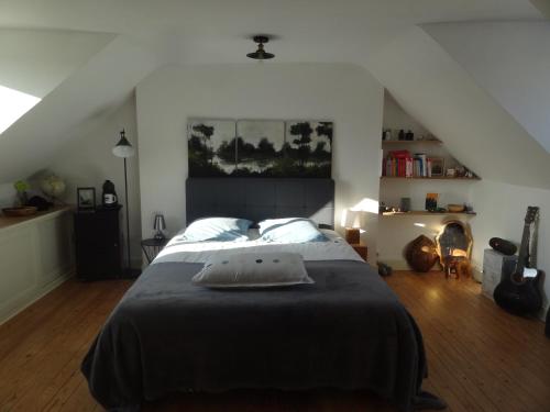 a bedroom with a large bed in a attic at Maison centre-ville et proche du Circuit des 24H in Le Mans