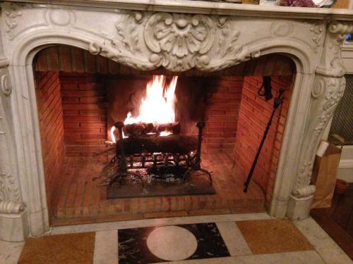 a fireplace with a large fire in it at Maison centre-ville et proche du Circuit des 24H in Le Mans