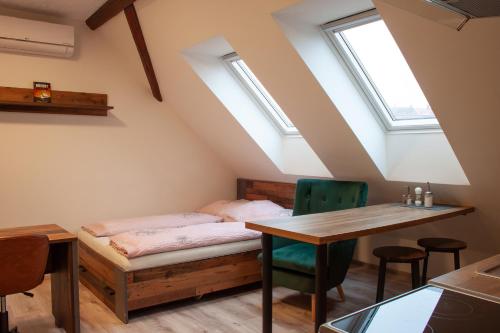 a bedroom with a bed and a table and chairs at Ubytování 1kk ve Zlonicích in Slaný