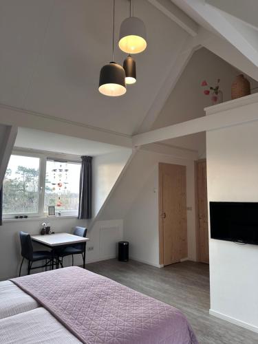 a bedroom with a bed and a table with chairs at 't lant van Texsel in De Koog