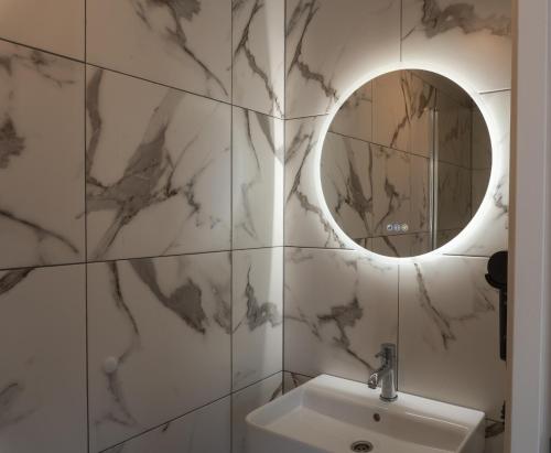 a bathroom with a sink and a mirror at CS Hotel in Amsterdam