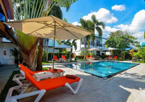 an umbrella and chairs next to a swimming pool at Phuket Airport Hotel in Nai Yang Beach