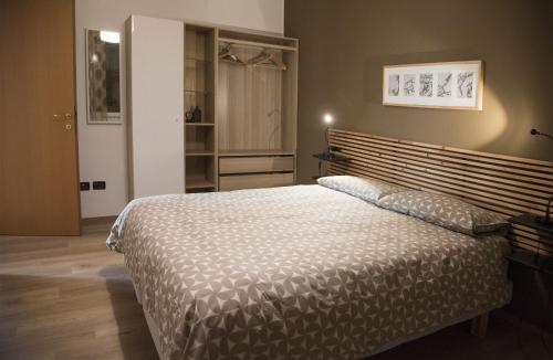 a bedroom with a large bed with a wooden headboard at La Casa di Emy in Solto Collina