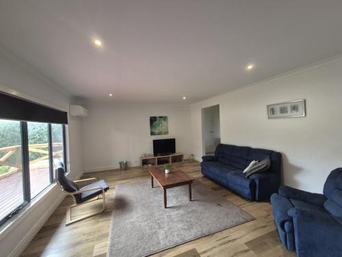 a living room with a blue couch and a table at Esperance Bay Retreat in Esperance