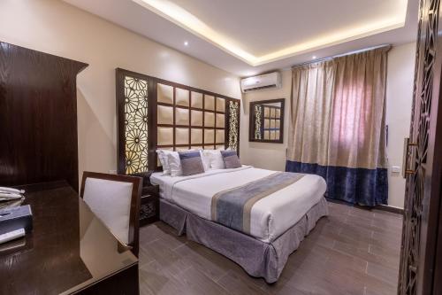 ein Hotelzimmer mit einem großen Bett und einem Schreibtisch in der Unterkunft Al Muhaidb Residence Al Malaz 7 - Economic in Riad
