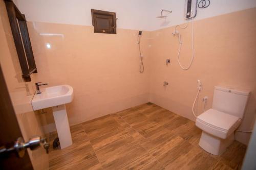 a bathroom with a toilet and a sink and a shower at Rainforest Hide View in Deniyaya