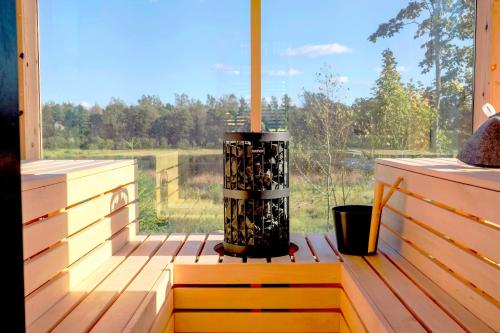 a screened in porch with a view of a field at Pulli Country Club - Private Sauna & River View in Pärnu