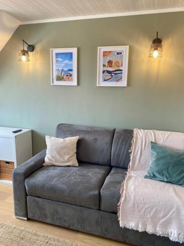 un canapé en cuir dans un salon avec deux coussins dans l'établissement Studio proche plage, à Neufchâtel-Hardelot