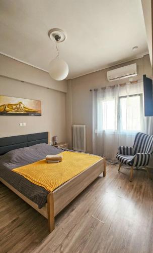 a bedroom with a large bed and a chair at Efrosini's by the sea apartment in Chalkida