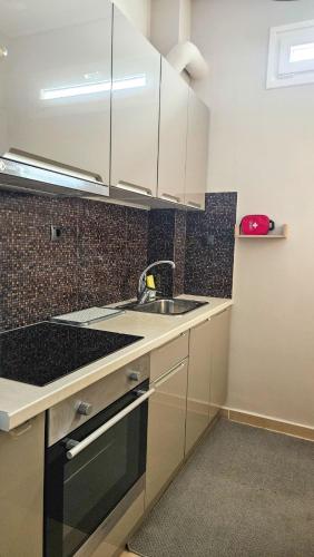 a kitchen with white cabinets and a sink at Efrosini's by the sea apartment in Chalkida