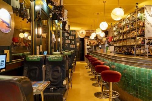 a bar with a row of bar stools at Hotel The Happy Traveler in Groningen