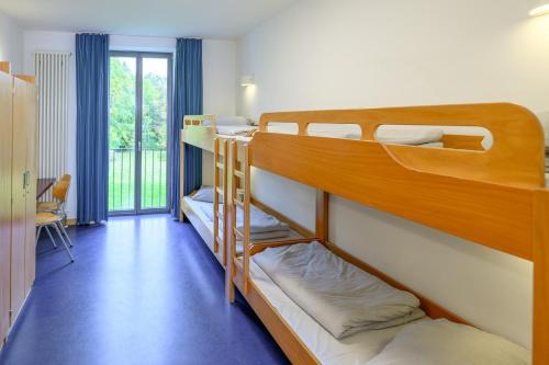 two bunk beds in a room with a balcony at Jugendherberge Otto-Moericke-Turm in Konstanz