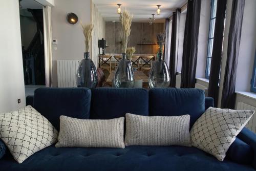 a blue couch with pillows in a living room at Villa d'Eaux in Villers-sur-Mer
