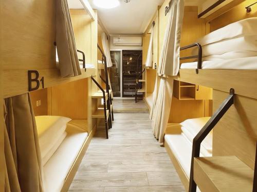 a corridor of a dorm room with bunk beds at 泊金青年旅舍-深圳北站店 in Shenzhen