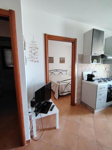 a room with a kitchen and a bedroom with a bed at Casa Ventaglio Verde in Valledoria