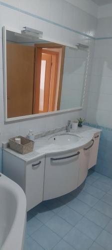 a white bathroom with a sink and a mirror at apartma Kiana in Šempeter pri Gorici