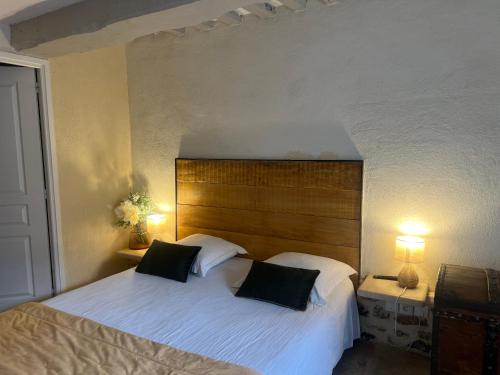 a bedroom with a large bed with two pillows at Le Petit Paradis in Honfleur