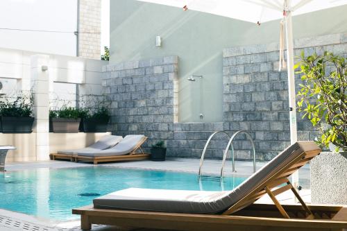 a swimming pool with a chaise lounge chairs and a swimming pool at Hotel Nestos in Omiš