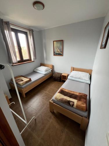a small room with two beds and a window at Apartamenty w Helu in Hel
