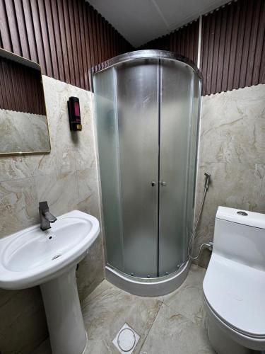 a bathroom with a shower and a toilet and a sink at Deira Guest house by PHM in Dubai