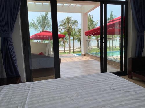 a bedroom with a bed and a view of a pool at Hải Tiến Resort in Mỹ Ðuc