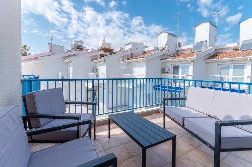 a balcony with two chairs and a bench and a building at Beach Escape Beachfront Apartment in Pyla