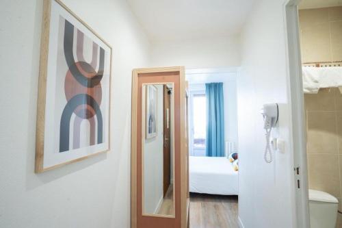 a room with a mirror and a room with a bed at Hôtel Edgar Quinet in Paris