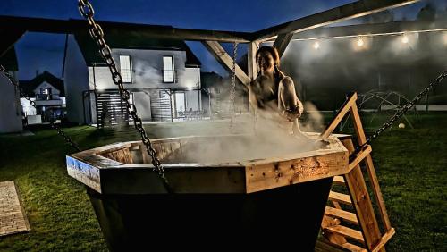 a man bathing in a hot tub in a yard at Zacisze w Karkonoszach in Karpacz