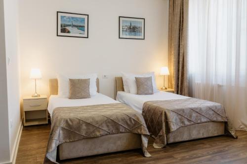 a hotel room with two beds and two lamps at Hotel N in Belgrade