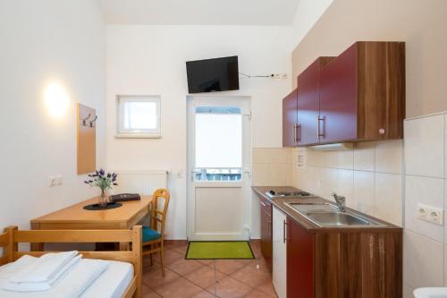 a small kitchen with a sink and a table at Apartmentdorf Flößerstube in Grossraming