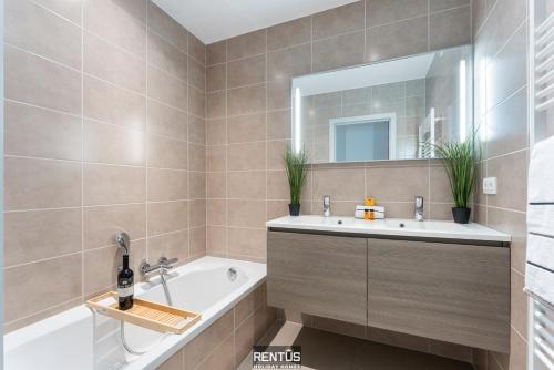 a bathroom with a tub and a sink and a mirror at Seange - with beautiful view and many facilities in Nieuwpoort