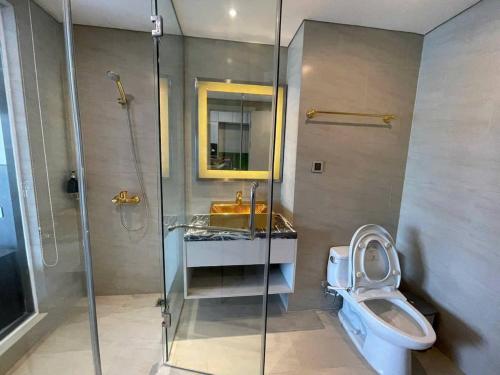 a bathroom with a shower and a toilet and a sink at Golden Bay Danang in Danang