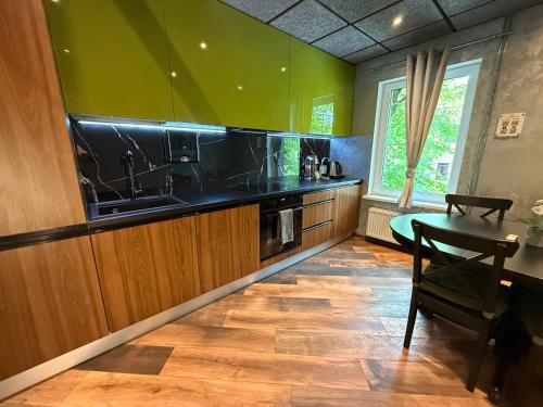 a kitchen with green walls and a wooden floor at BRIVIBAS RESIDENCE - WAVE, free PRIVATE parking, free WIFI, self check-in in Riga