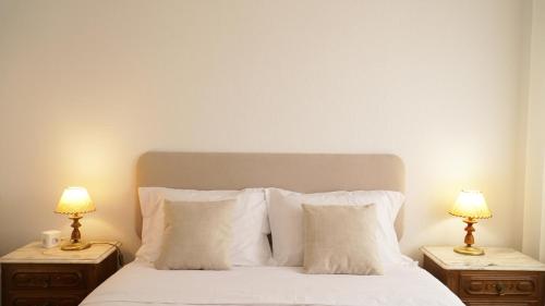 a bedroom with a white bed with two night stands at Cantinho Dos Avós - Alojamento Local in Canas de Senhorim