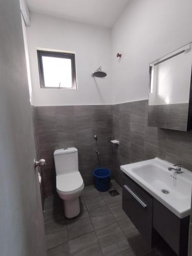 a bathroom with a toilet and a sink at Halimah Guesthouse in Putatan