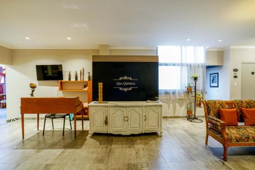 a living room with a piano and a large screen at Casa Carmelia La Condesa in Mexico City