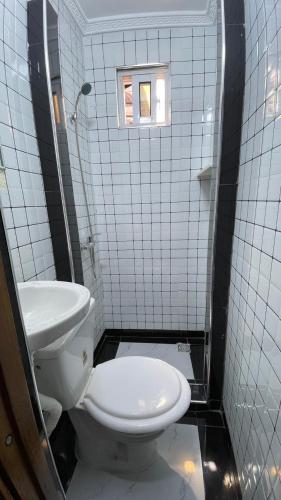 a bathroom with a toilet and a sink at Jumeaux Studio in Luanda