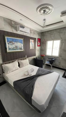 a bedroom with a large bed in a room at Jumeaux Studio in Luanda