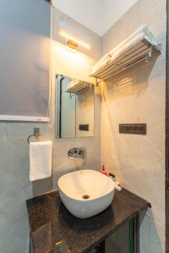 a bathroom with a white sink and a mirror at Milestone Resort in Thūr