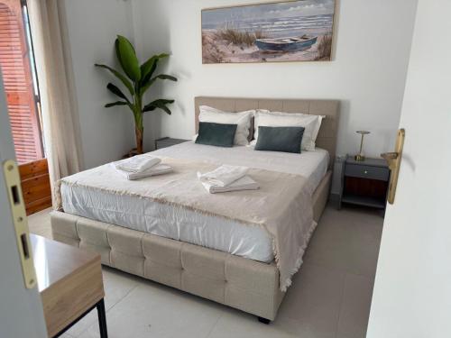 a bedroom with a large bed with two towels on it at NIVAS Apartment Pefkochori in Pefkochori