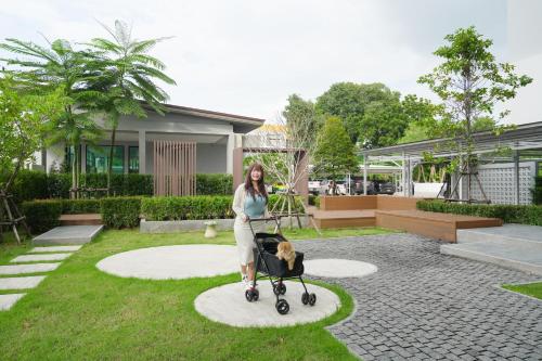a woman with a dog in a stroller at The Kite Hotel Bangsaen by Koko in Ban Laem Thaen
