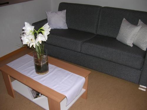 a vase with white flowers sitting on a coffee table at Appartements Mantinger in Mauterndorf