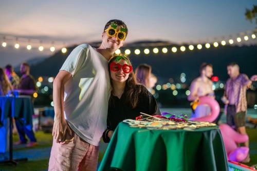 a man and a woman standing next to a table with food at HOMA Phuket Town in Phuket