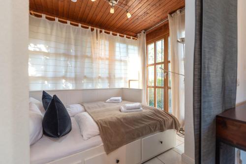 a bedroom with a bed with pillows and a window at Ferienhaus MeerGenerationen in Ueckeritz