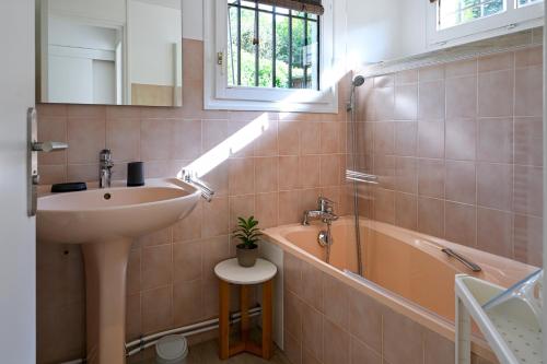 a bathroom with a sink and a bath tub at La Petite Sommière in Besançon