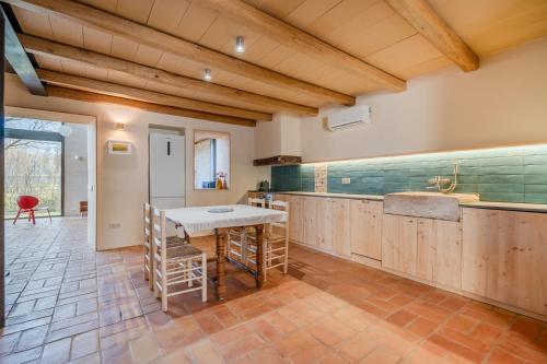 a kitchen with wooden cabinets and a table and chairs at Flateli Cornellà del Terri in Santa Llogaia del Terri