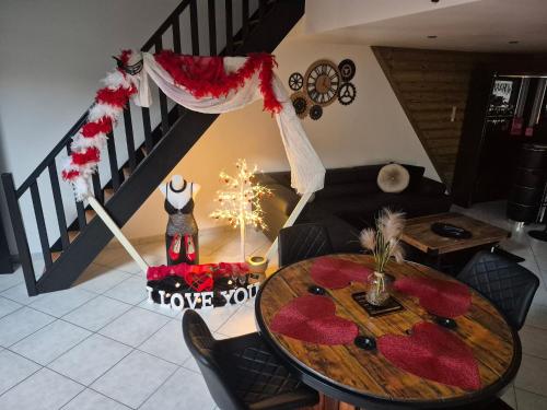 a living room with a table and a staircase at Love Room La Crèche Romantique in Bogny Sur Meuse